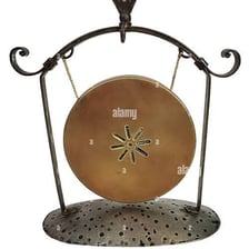 A mallet striking a large gong.