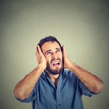 An annoyed person covering their ears