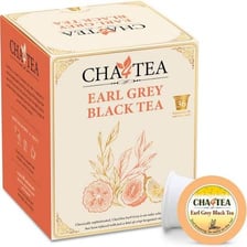 A cup of Earl Grey tea beside loose tea leaves and citrus.