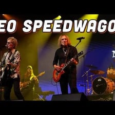 REO Speedwagon performing onstage at a concert.