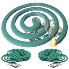 A green mosquito coil burns in a spiral and gives off a thin wisp of smoke.