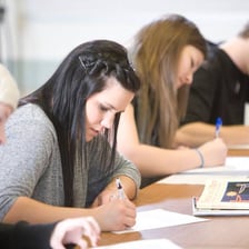 A student writing notes during a classroom lesson.