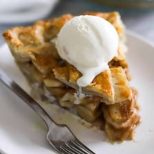A slice of pie served with a scoop of vanilla ice cream.