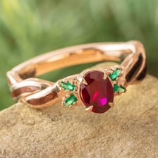 A red ruby and a green emerald displayed as gemstones.