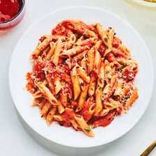 A bowl of penne pasta in a creamy vodka sauce.
