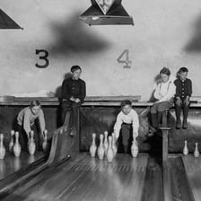 Ten white bowling pins arranged at the end of a bowling lane.