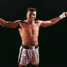 Muhammad Ali posing in a boxing-related portrait.