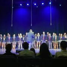 A group of singers performing together on a stage.