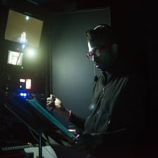 A theater stage manager signaling an actor to begin