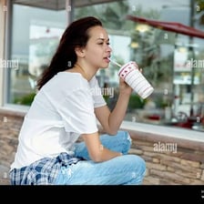A person drinking from a beverage through a straw