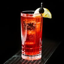 A fizzy sloe gin cocktail served in a glass.