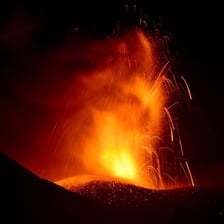 An erupting volcano spewing ash and lava.