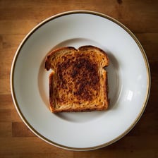A piece of heavily browned toast on a plate