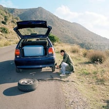 A car with a visibly flat tire.