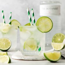 A gin and tonic in a glass garnished with lime