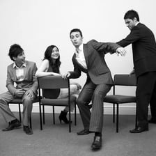 People playing musical chairs as one participant sits in a chair.