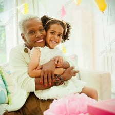 A grandmother embracing a grandchild.