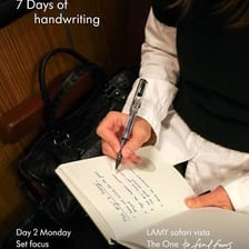A person writing a poem in a notebook.