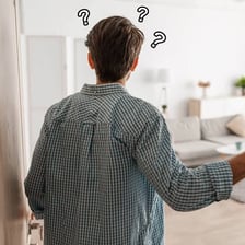 A person standing near a doorway asks whether they are blocking the way.