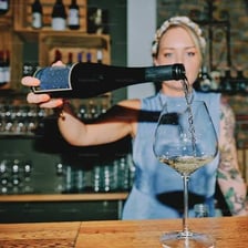 A bartender pouring a beverage into a glass