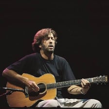 Eric Clapton performing with an electric guitar.