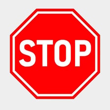 A red octagonal STOP sign beside a roadway.