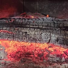 Gray ash collected at the bottom of a fireplace.