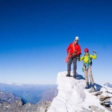 A climber ascending a rocky mountain in the Swiss Alps.