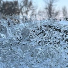 A surface covered in frost and ice crystals.