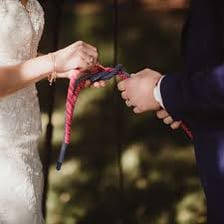 A wedding couple participating in a knot-tying ceremony.