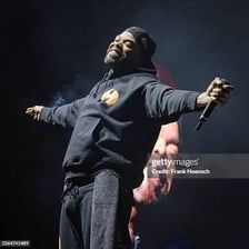 A hip-hop performer rapping into a microphone