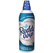 A can of Reddi-Wip whipped cream beside a dessert.