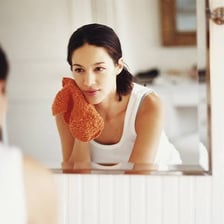 A person gently patting their face with a towel.