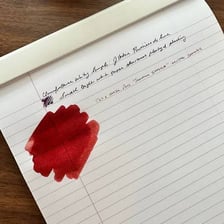 A fountain pen resting on or writing on paper.