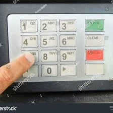 A person entering a number on an ATM keypad
