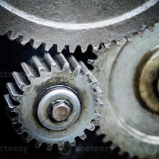 A metal cog meshing with other gears in a machine.