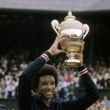 Arthur Ashe playing tennis at Wimbledon.