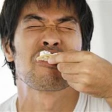 A person eats food and chews it before swallowing.
