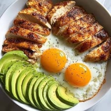 A chicken standing beside an egg