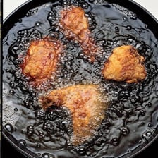 Food being deep-fried in a pot of hot oil