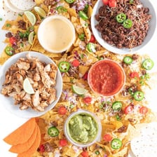A table displaying nachos, salads, oats, and dessert