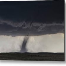 A funnel-shaped tornado extending from a storm cloud