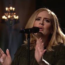 Singer Adele performing onstage with a microphone.