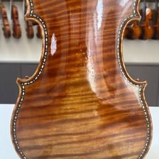 A close-up of a fiddle, the instrument named in the comparison