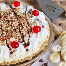 Several pies with browned crusts arranged for a Thanksgiving meal