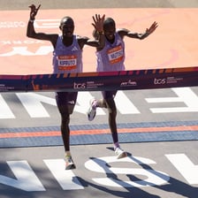 A runner approaching a finish line marking the end of a race