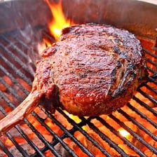 A steak being seared on a hot grill