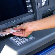 An automated teller machine with cash bills being dispensed