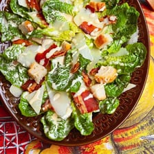 A Caesar salad with romaine lettuce, croutons, and Parmesan cheese.