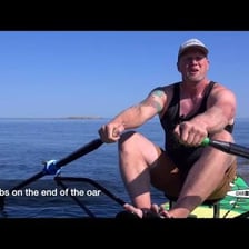A rower using an oar to propel a boat.